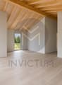 Grand séjour lumineux / an empty room with wooden floors, white walls and a large window