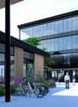 glass facade, modern design, plants, bicycles, multiple entrances, people walking, bicycles parked