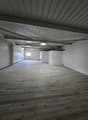 large open room, wooden floors, white walls, metal ceiling, small window