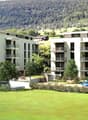 Two apartment buildings, modern architecture, large balconies, open green spaces, playground