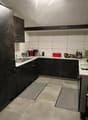 tiled floor, dark wood cabinets, countertop with modern sink, coffee machine, toaster, plants