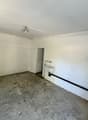 Unfinished basement or storage room with concrete floor, white walls, and a utility sink or basin on the wall.