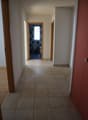 empty hallway, tiled floor, bathroom on the right