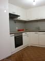 modern kitchen with white cabinetry, dark countertops, oven, dishwasher, sink, faucet