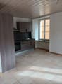 empty kitchen with tiled floor, wooden cabinets, black countertop, sink, oven, window