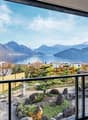 View of mountains, lake, trees and buildings from balcony