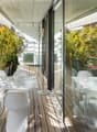 modern design white table and chairs, glass railings, plants, wooden floor