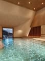 A swimming pool in a room with a fireplace and view