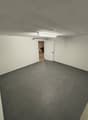empty room, white walls, gray tiled floor, white door, fluorescent light
