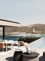 modern building, large terrace, kitchen island, large outdoor pool, dining table, lounge chairs, view of the lake