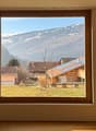 large window with view of mountains and houses