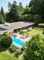 Modern house with flat roof, large swimming pool, garden, and solar panels