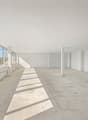 Empty room with large windows, tile flooring, white walls, white ceiling, pillars