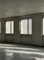 Empty room, large windows, white walls, wooden floor