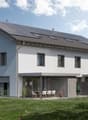 2-story house with solar panels on the roof, white exterior walls, large windows, patio with outdoor furniture, and a grassy yard with flowers.