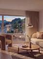 living room with large windows, couch, armchair, coffee table, floor lamp, TV, rug, picture frame