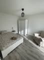 bedroom with bed, nightstand, wardrobe, couch, lamp