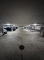underground parking lot, white and black painted pillars, multiple parking spaces