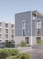 A modern apartment building, grey concrete facade, glass windows, balconies, parking area