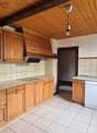 wooden cabinets, stainless steel oven, gas stove, wooden ceiling, white tiles, dishwasher