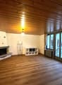 wooden floor, ceiling, white walls, fireplace, large windows, sliding door