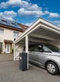 House with solar panels, carport, and a silver car parked under it