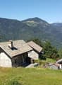 Mountain chalet with mountain view, two structures with stone walls, a fence