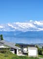 Detached house with solar panels, garage, and a view of the lake and mountains