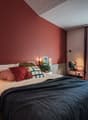 twin bed, bedside table, red wall, balcony, window, curtains