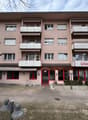 apartment building, balconies on each floor, awning above entrance, Zahnarzt text below top balcony