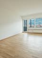empty room, wooden floor, white walls, large windows, balcony