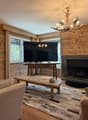 Coin salon avec cheminée et TV / Lounge area with fireplace and TV / Area salotto con camino e TV