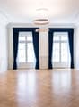 wide room, fireplace, hardwood floors, large windows, ceiling lamps
