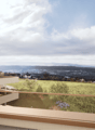 Balcony with a view overlooking a hilly, grassy landscape with a town in the distance. The apartment building has a modern, minimalist design with large windows and a terrace.