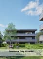 Modern multi-story apartment building with balconies, surrounded by lush greenery and trees. The building has a sleek, contemporary design with large windows and a mix of glass and dark exterior materials. There are people visible in the outdoor seating a