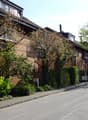 apartment buildings with brick facades, windows, and balconies, greenery, street with sidewalk