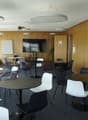 modern office room with round tables, chairs, wooden walls, large windows, whiteboard, TV