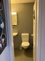 Small bathroom, tiled walls, white sink, white toilet, mirror