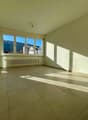empty room, large window, tiled floor, white walls, radiator