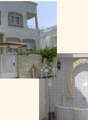 White facade, white windows, balcony on second floor, raised ground floor with intricate designs