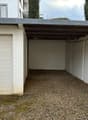 Empty garage with gravel floor and metal roofing
