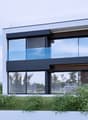 Contemporary 2-story house, glass walls, balcony, raised ground floor, spiral staircase, panoramic view