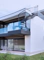 Contemporary style, white exterior, glass windows, spiral staircase, raised ground floor, large balcony