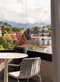 balcony, outdoor table and chairs, potted plant, city and mountain view