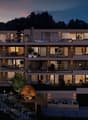 modern apartment complex, several floors, balconies, illuminated at night, scenic view
