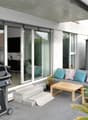 BBQ grill, wooden sofa, table, potted plants, tiles floor