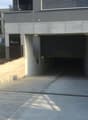 Parking lot for guests, entrance to the building, concrete walls, underground parking, iron railings, sign indicating the height restriction