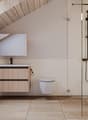 wooden ceiling, white tiled walls, white sink, wooden cabinet, white toilet, glass shower enclosure, shower head, washing machine