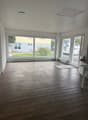 large windows, wooden floor, white walls, empty room