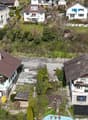 Swiss-style houses, brown roofs, green shutters, surrounded by greenery, driveways, solar panels on some roofs
